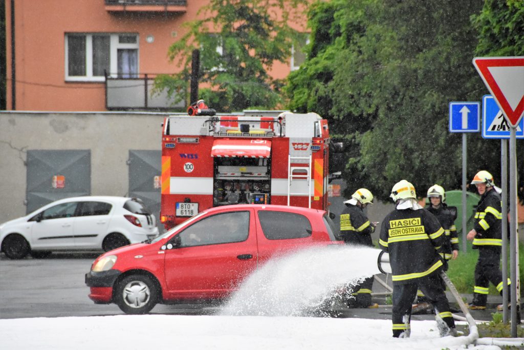 Hasiči stříkají pěnu na závodní trať